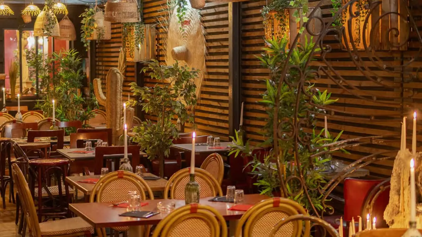 Terrasse de La Tasca à Marseille éclairée à la bougie, chaises en rotin et cactus en paille