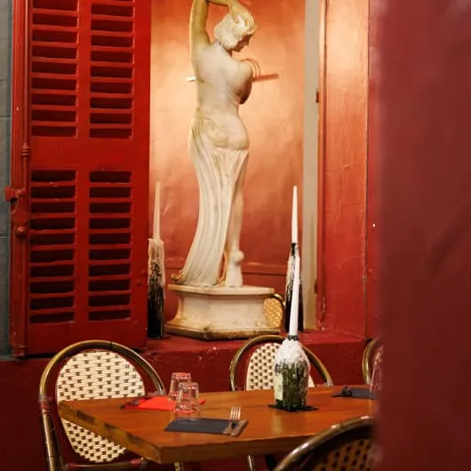 Statue et volets rouges dans la salle de La Tasca