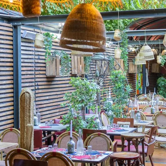 Terrasse couverte de La Tasca avec ses suspensions en osier, en plein cœur de Marseille