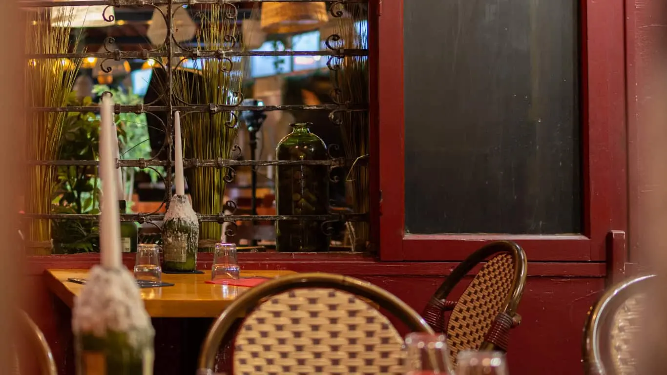 Table aux bougies devant la fenêtre rouge de La Tasca